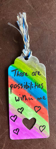 There are possibilities within me is handwritten on a rainbow background. Colourful thread.