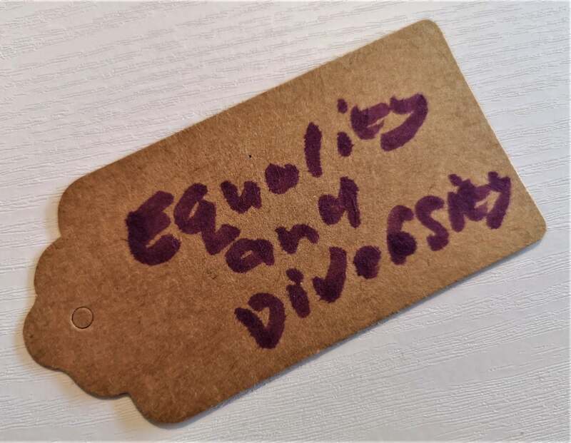 Brown parcel label with handwritten text, 'Equality and Diversity'. Pauline Heath.