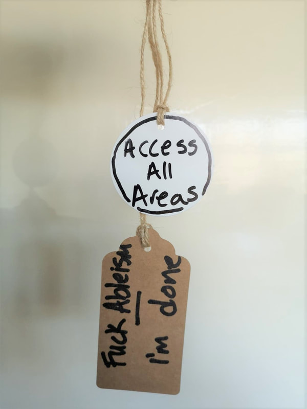 Two labels hanging on string. A whote circle reads Access All Areas and a brown label reads F*ck ableism, I'm done.
