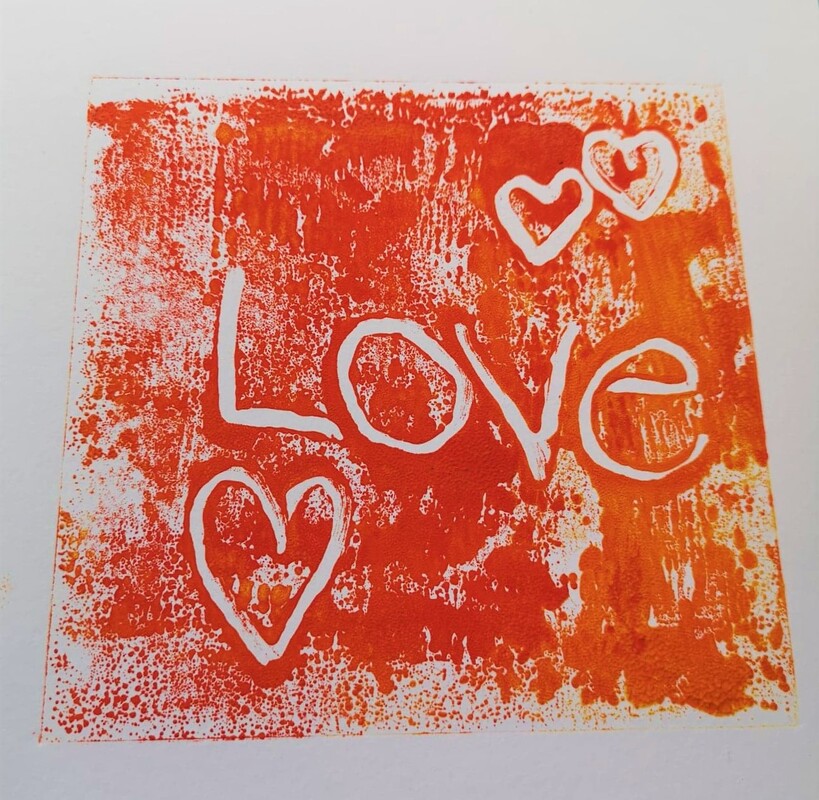 A mix of shades of bold orange ink with patches of white background showing through and the word 'love' and three love hearts marked out from the white background. 