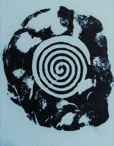 A bold black print on a blue back ground. It is an irregular chape with a spiral from a wood block at its centre, suggestive of an ammonite fossil.  By Vici Wreford-Sinnott