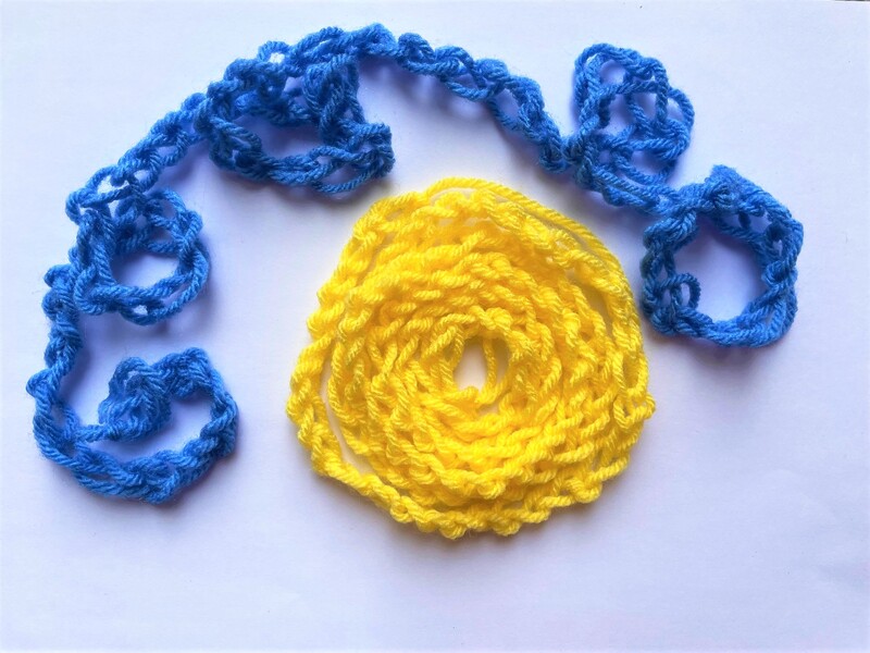 Finger knitting - a yellow sun and blue clouds. 