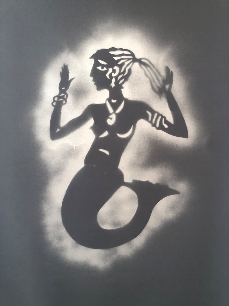 Using a handcut stencil of a mermaid facing to the left, there are details of a ponytail,  earring, pendant necklace, bangles, breasts, nipples and buttocks and a mermaid's tail. It had been spray painted white into a charcoal background. 