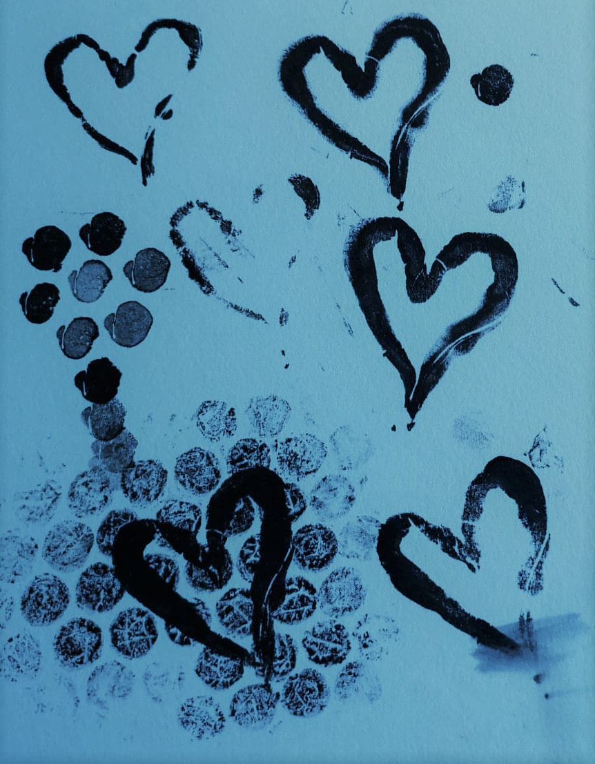 An abstract graphic image of black ink on a blue background. At the bottom is a light bubble wrap print, overlaid with a bold lined black love heart. There are five other love hearts from the same print with varying degrees of difference in shade and position. One black dot is in the top right corner and a series of dots suggest the shape of a flower and stem. By Vici Wreford-Sinnott.